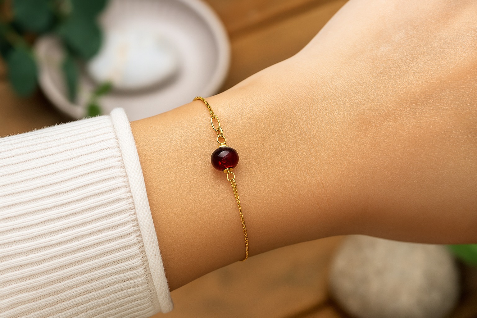 Pozlátený náramok s jantárovou korálkou višňovej farby